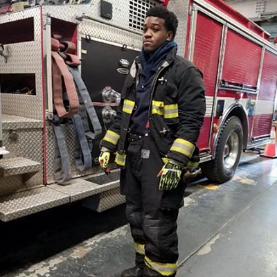 A man in black and yellow fire fighter 's uniform.
