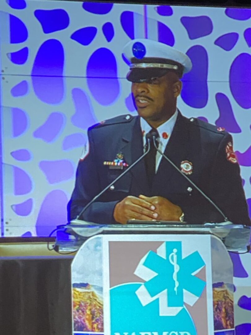A man in uniform is speaking at a podium.